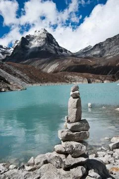 Harmony: stone stack and sacred lake near gokyo Stock-Fotos
