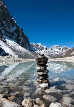 Harmony: stone stack and sacred lake near gokyo Foto stock