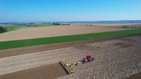 Harrowing a large field with a large crawler tractor. Soil cultivation before Stock Footage 165871198