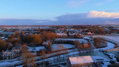 Harsh cold winter scene of a quite Lincolnshire village covered in early Vídeos de archivo 334315712