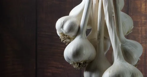 The harvest of a bunch of garlic hung drying and spinning slowly Video stock 154058524