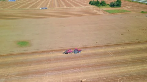 Harvest time long drone shot of a tractor and baler in open field Stock-Footage 280934278