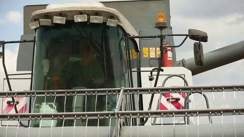 Harvester auger through the pipe pours wheat into a truck Stock Footage 74480347