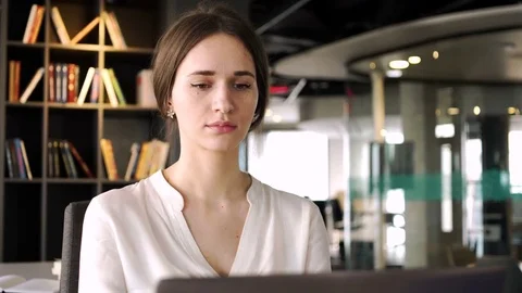 Harworking beautiful young woman work on laptop computer with business papers Stock Footage