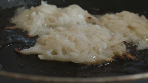 Hash browns are turned over with a spatula on a frying pan Stock Footage 108006799