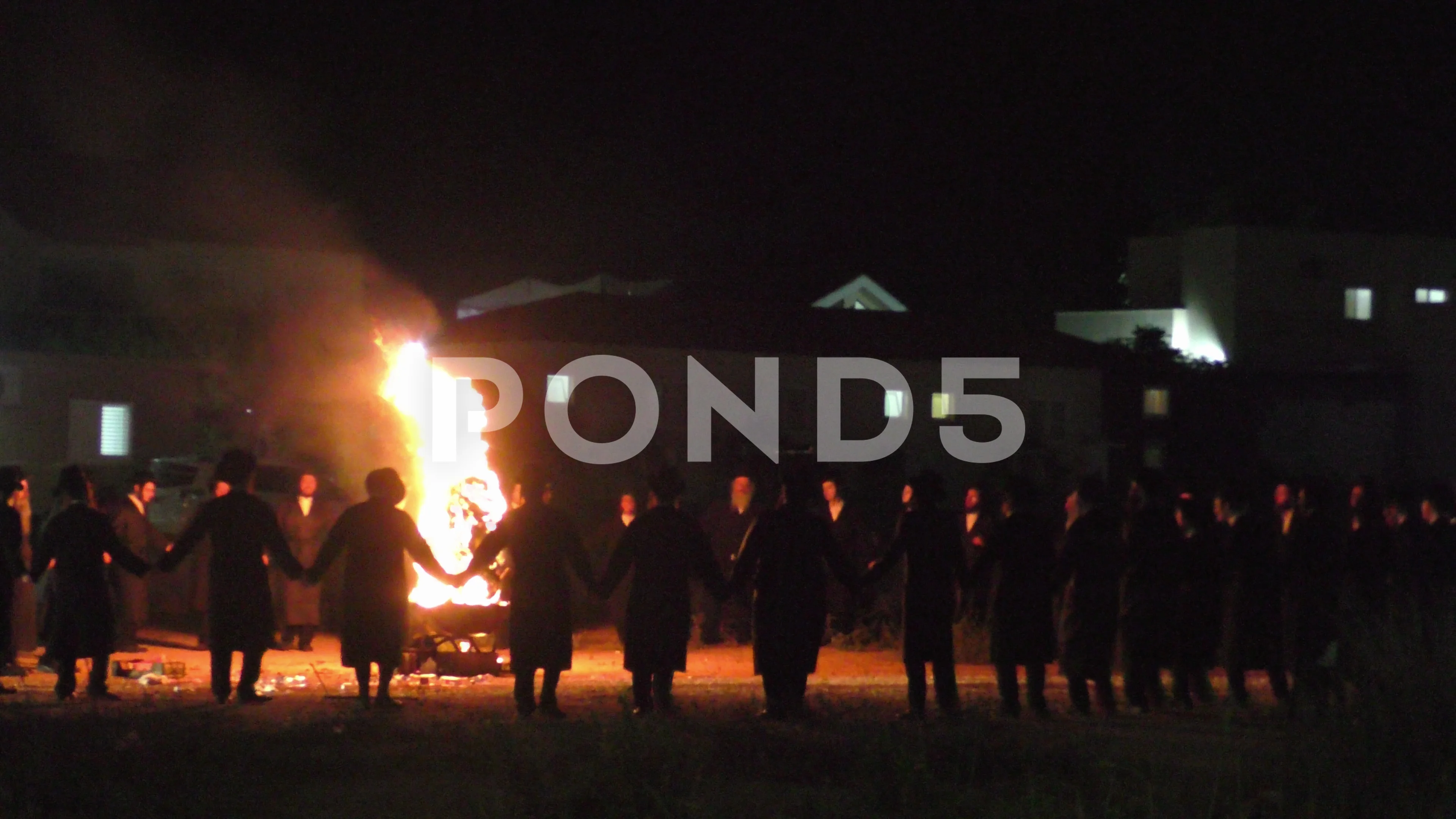 Hasidic Jews dancing in a circle around bonfire in the small village Meron