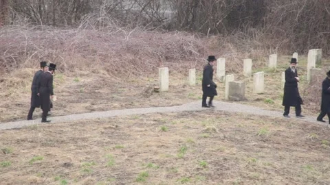 Hasidic pilgrims walking the pass through the ancient Remuh (Remah) Cemetery Stock Footage 150032392