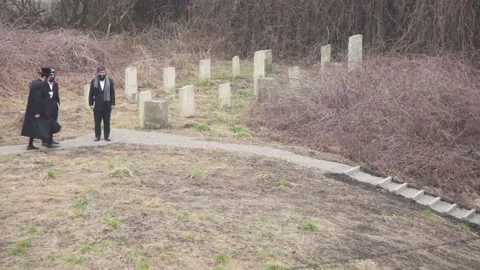 Hasidic pilgrims walking the pass through the ancient Remuh (Remah) Cemetery Stock Footage 150032657
