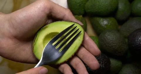 Hass avocado pulp being stirred with a fork, slow motion Stock Footage 301017374