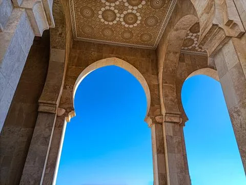 Hassan ii mosque arches framing clear blue sky in Casablanca Stock Photos