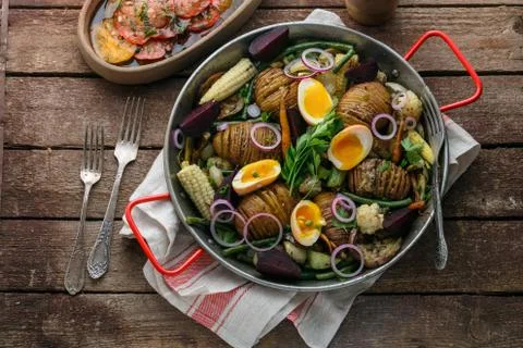 Hasselback potatoes with vegetables in a pan Stock Photos