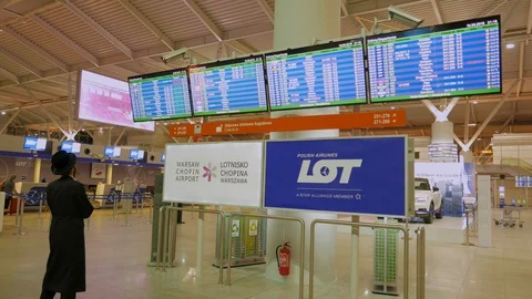 A Hassidic person looking at Departures Board. International Chopin Airport Stock Footage 89727449
