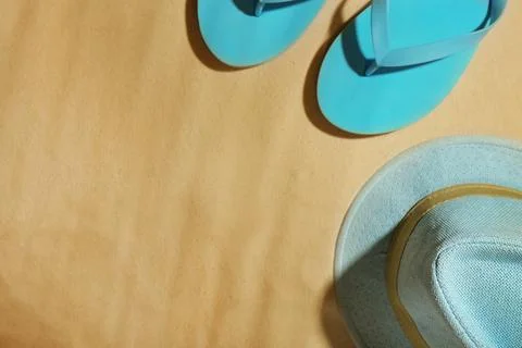 Hat and flip flops on beach sand, top view. Space for text 스톡 사진