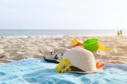 Hat and flip flops on sandy beach Stock Photos