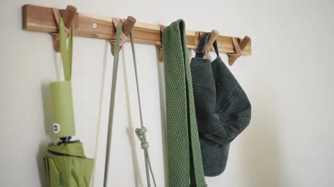 Hat and jacket hanging on a hook in the hallway Vídeo Stock 335615128