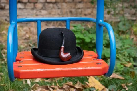 Hat and smoking pipe on a swing close-up Stock Photos