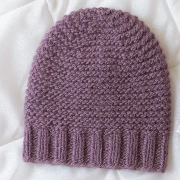 Hat bound manually of dark red wool Stock Photos