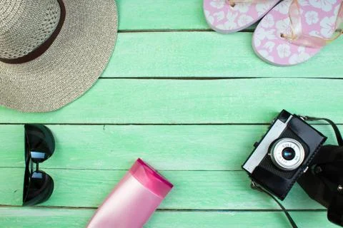 Hat, camera, bag, glasses, sunscreen on a summer wooden background. Top view  Stock Photos