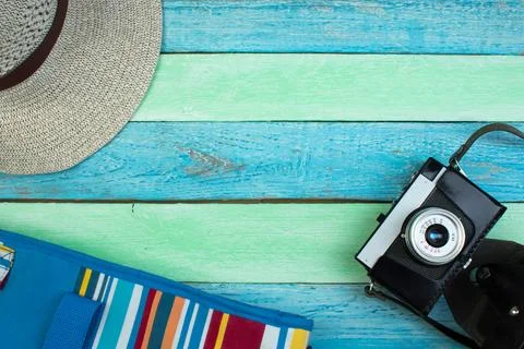 Hat, camera, bag, glasses, sunscreen on a summer wooden background. Top vie.. Stock Photos