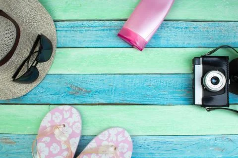 Hat, camera, bag, glasses, sunscreen on a summer wooden background. Top vie.. Stock-Fotos