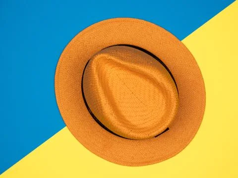 Hat in flat lay on vivid blue and yellow background colors Stock Photos