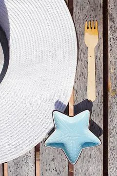 Hat, fork and plate in the form of a starfish on a wooden table Stock Photos