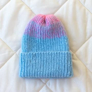 Hat with knitted Welt turned manually with a gradient of blue and pink wool Stock Photos