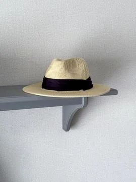 Hat placed on a gray shelf in a simple room Stock Photos