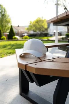 Hat placed on table in outdoor park area on a sunny afternoon with green gr.. Фото