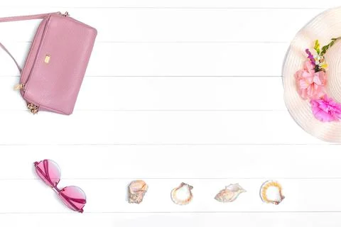 Hat, shells and handbag on a light wooden background 库存照片