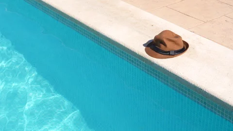 A hat is sitting on the edge of a pool Stock Footage 278001188
