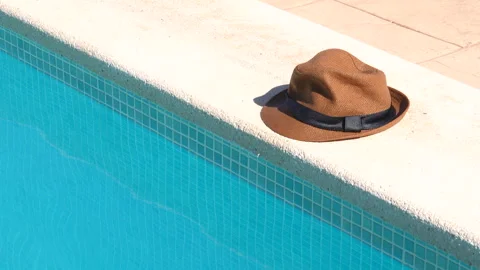 A hat is sitting on the edge of a pool Stock Footage 278001237