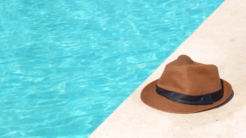 A hat is sitting on the edge of a pool Stock Footage 278001246