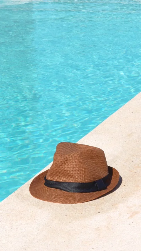 A hat is sitting on a poolside Stock Footage 277999961
