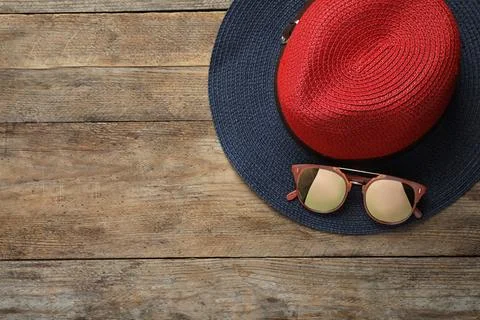 Hat with sunglasses and space for text on wooden background, flat lay. Beach  Stock-Fotos