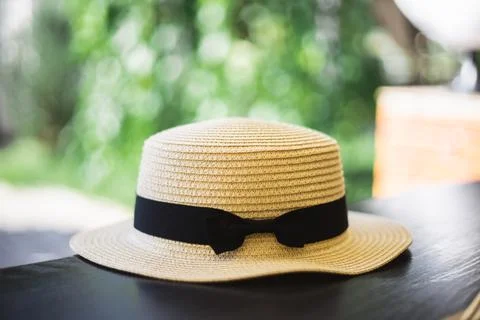 Hat on the table. Straw lady's hat with a black ribbon. Concept of rest and v Stock-Fotos