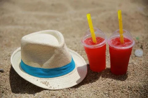 Hat with two cold drinks on beach Stock Photos