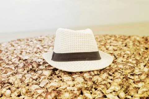 Hat white lies on a shell beach design vacation on the sea Stock Photos