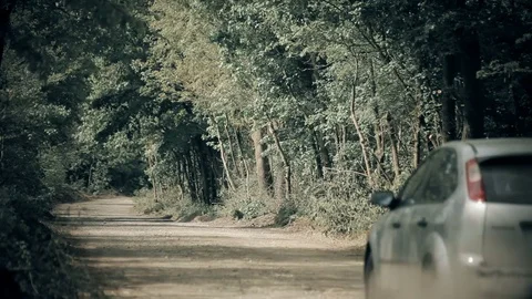 Hatchback Sedan with Trailer Running Fast on Gravel Road Stirring Up Dust Stock Footage