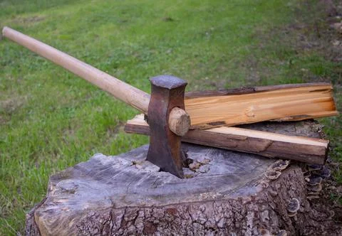 Hatchet stuck in a log while chopping wood for the winter. Stock Photos