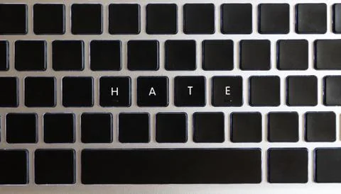 Hate caption isolated on notebook keyboard with blank keys. Stock Photos