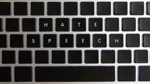 Hate speech caption isolated on notebook keyboard with blank keys. Stock Photos