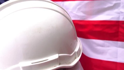Hats and various labor protective equipment is placed on the flag of the United Stock Footage 106396203