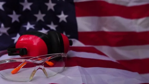 Hats and various labor protective equipment is placed on the flag of the United Stock Footage 106396397