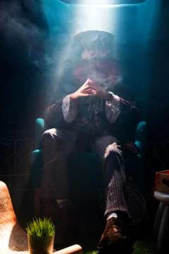 The hatter sits in a pensive posture Stock Photos