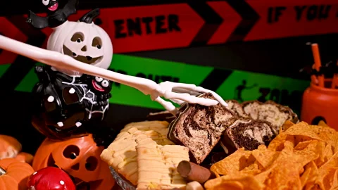 Haunted Halloween Table Setting: Skeleton Hand take Cookie Stock Footage 251492859