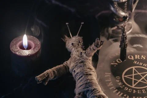 A haunting occult setup featuring a pendulum, mystical symbols, candles, a Stock Photos