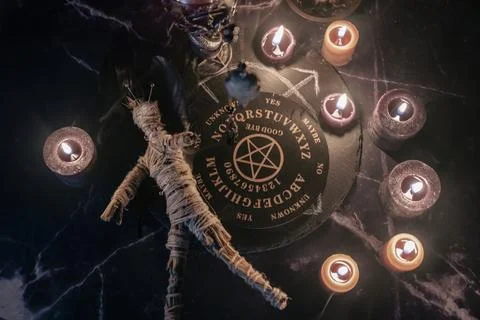 A haunting occult setup featuring a pendulum, mystical symbols, candles, a Stock Photos