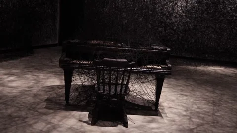 A hauntingly beautiful piano enveloped in a dense web of black threads, evoking  Stock Footage 304358244