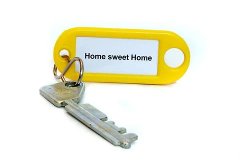 Hausschluessel mit Etikette und der Aufschrift Home sweet Home, Freistelle... Stock Photos